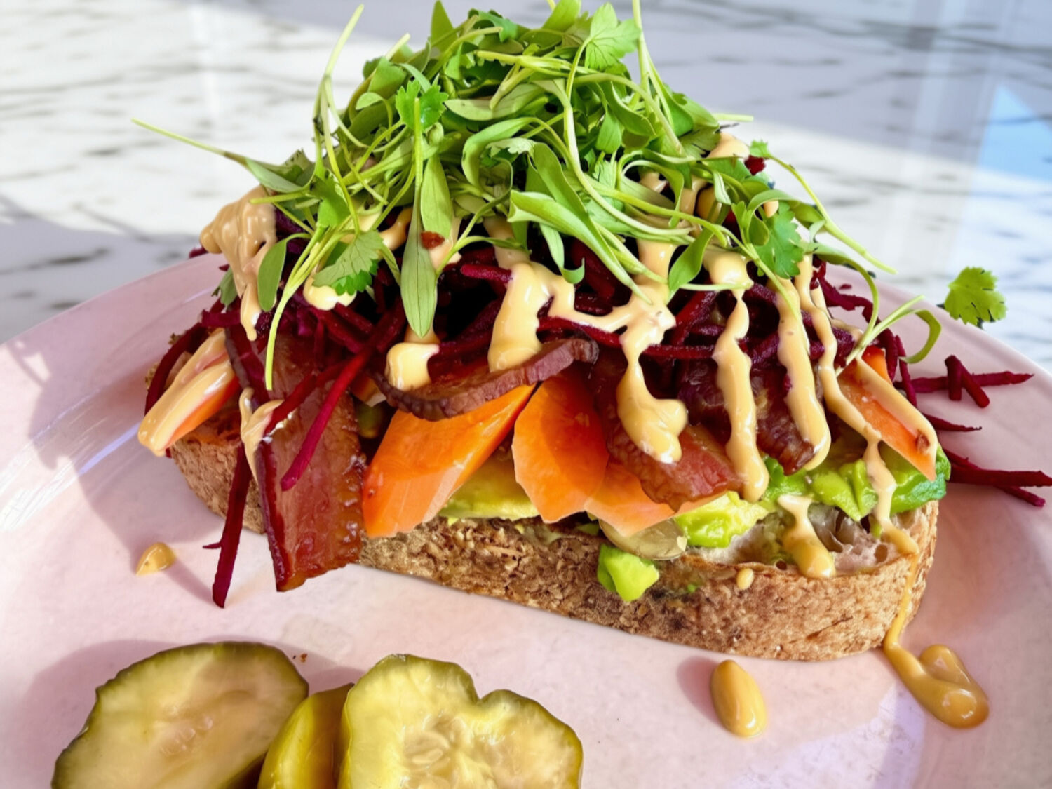 Fall Hipster Toast topped with avocado, vegetables, microgreens, and pumpkin seeds at The Baker and the Cakemaker