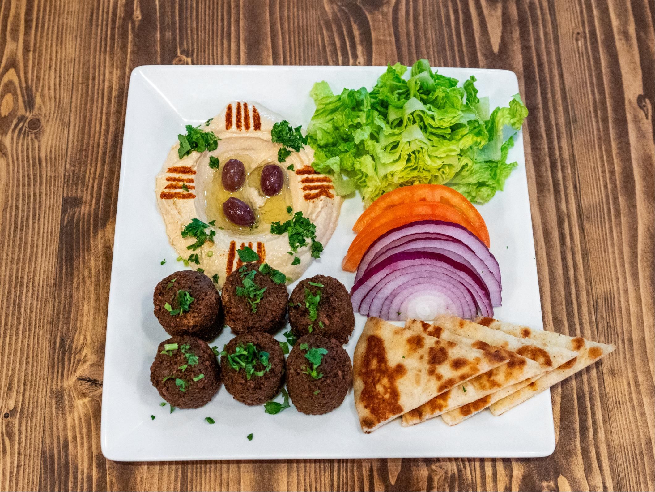 Falafel Platter With Hummus & Lettuce Tomatoes, And Onions Or With Choice Of Your 2 Sides.
