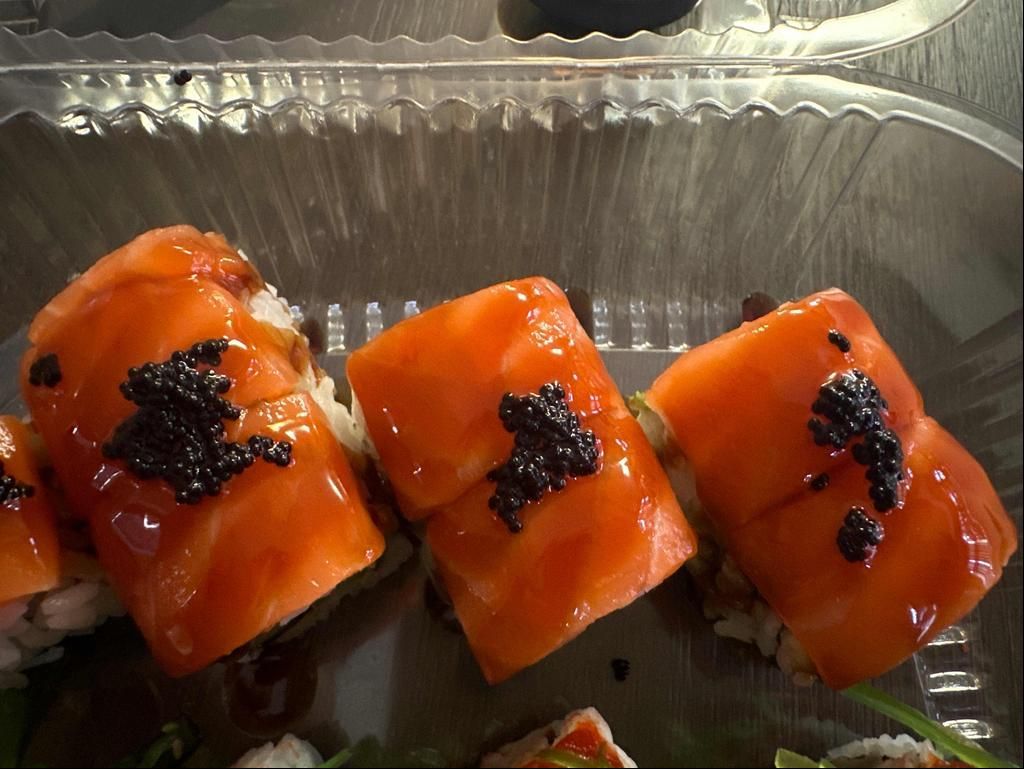 Black Jack Roll - Rolled with eel, avocado and cucumber, topped with fresh salmon, black tobiko and eel sauce.