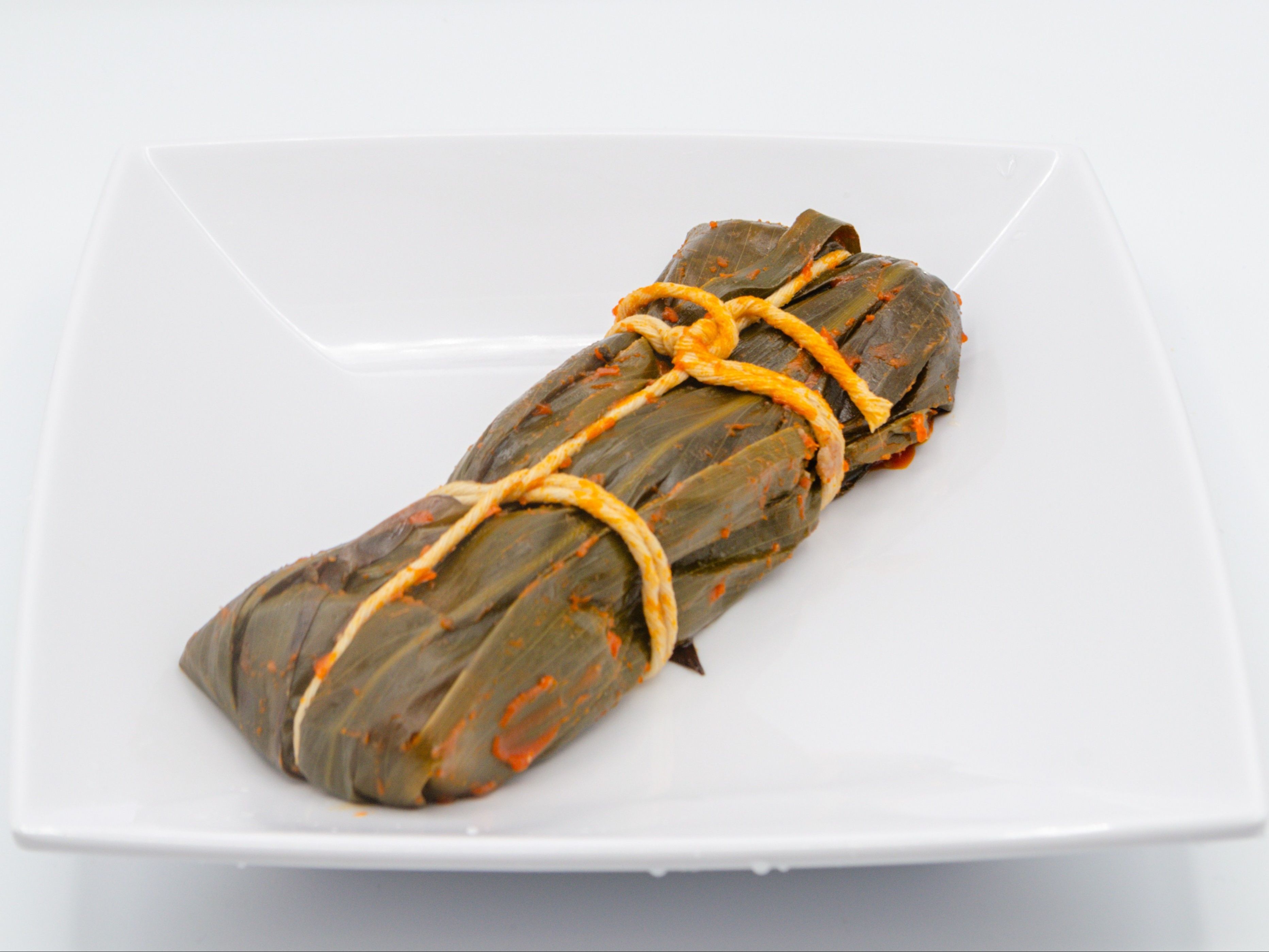 Pasteles - Spicy from Yama's Fish Market — One piece of Puerto Rican–inspired local favorite made with seasoned pork and vegetables wrapped in banana leaf flavored with our unique spicy sauce
