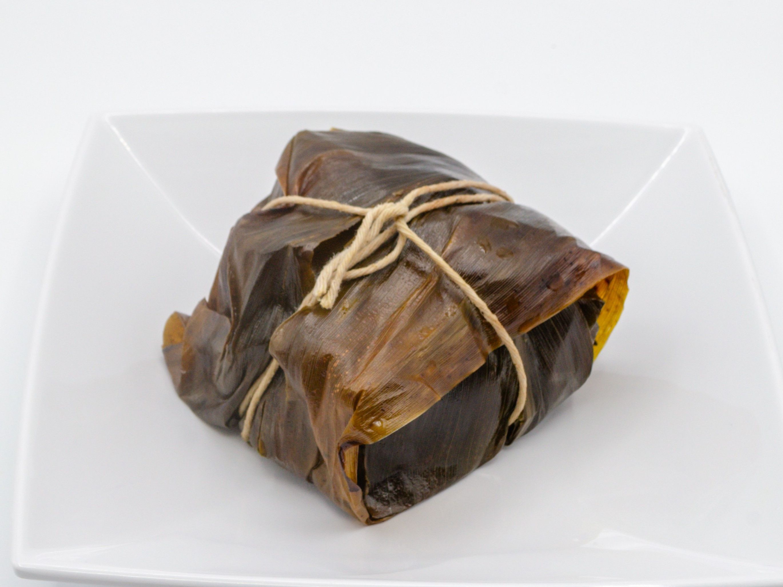 Lau Lau - Pork & Chicken from Yama's Fish Market — Our signature lau lau made with pork, chicken, and luʻau leaf, wrapped in ti leaves and slow-cooked until tender.