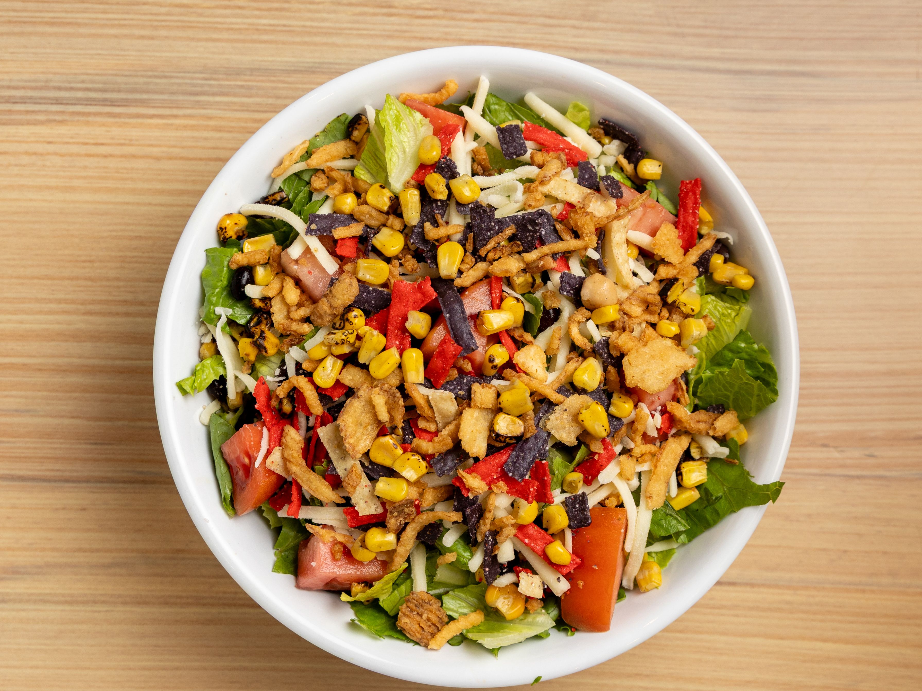 Baja Salad - Romaine, black beans, rstd corn, dice tom, cilantro, monterey jack, tortilla strip, onion crisp, Chipotle dressing