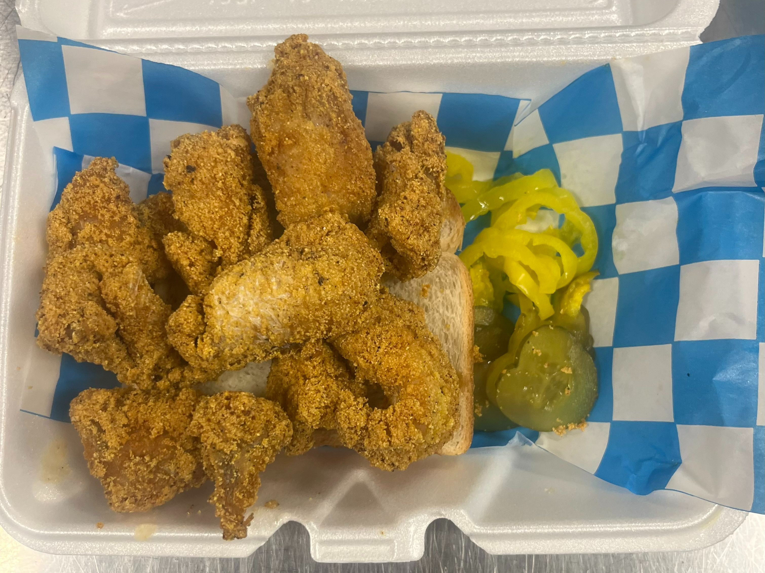 1/2 Lb Catfish Nuggets Sandwich with Pickles and Banana Peppers.